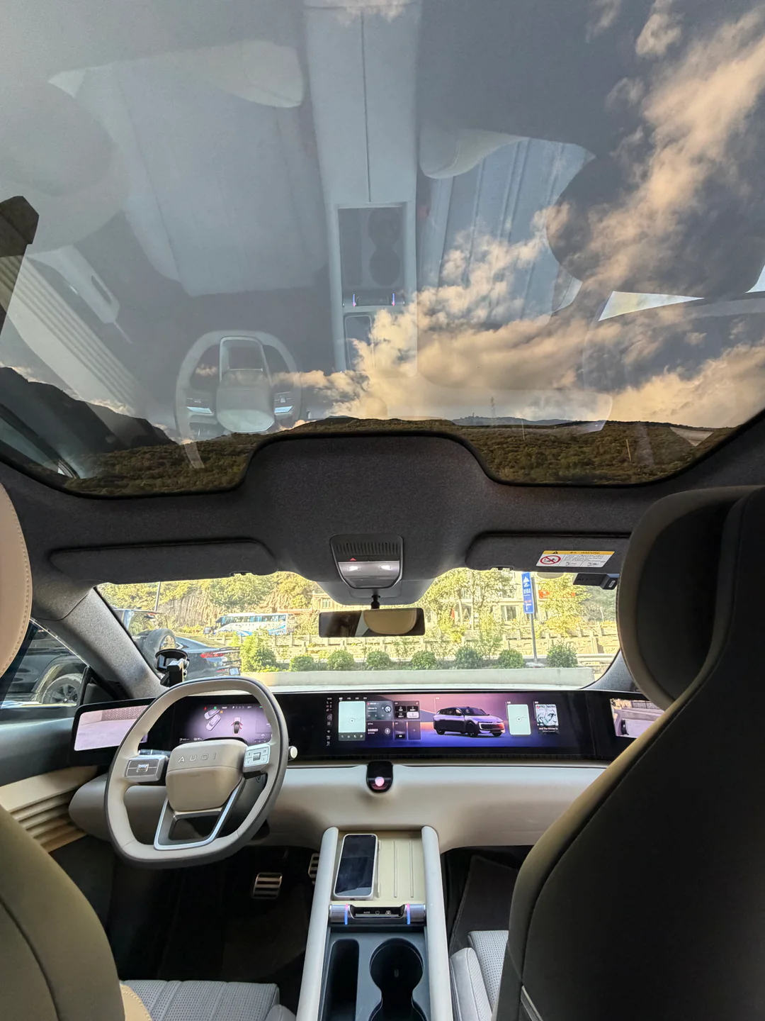 The panoramic-roof interior of the car at dusk