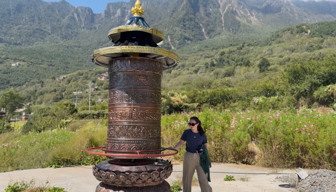 Eva walking past a Tibetan prayer wheel