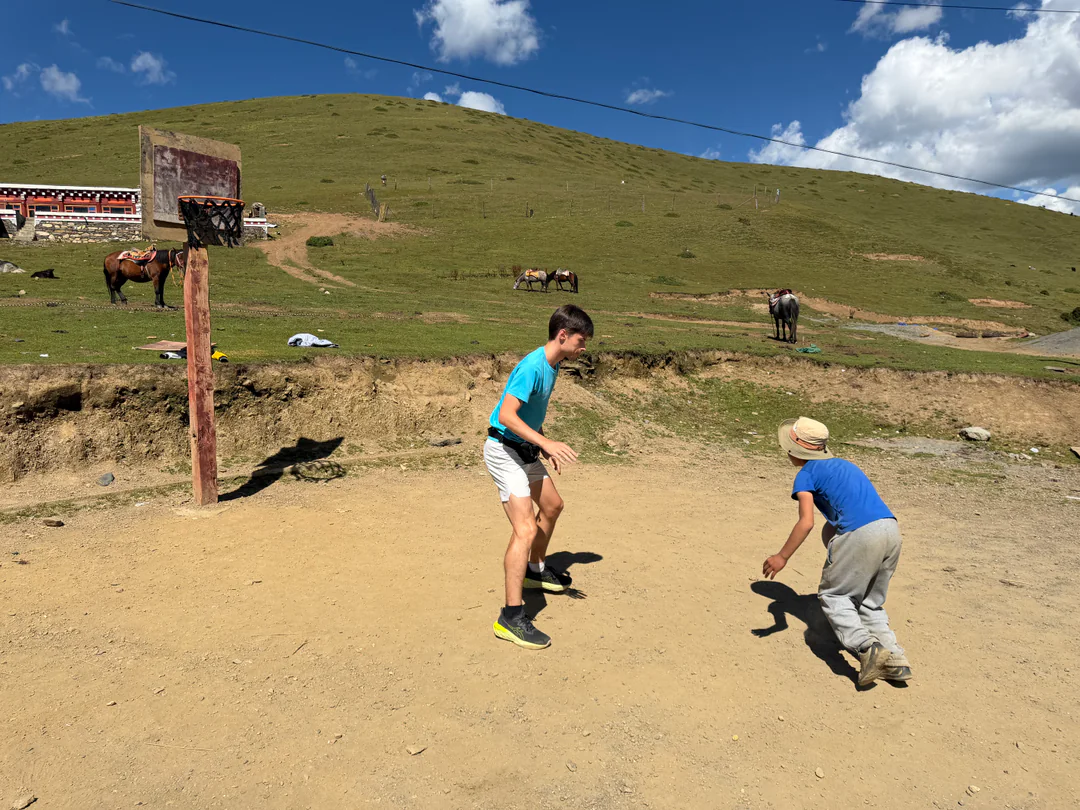 Martin playing basketball with local boys on the grassland
