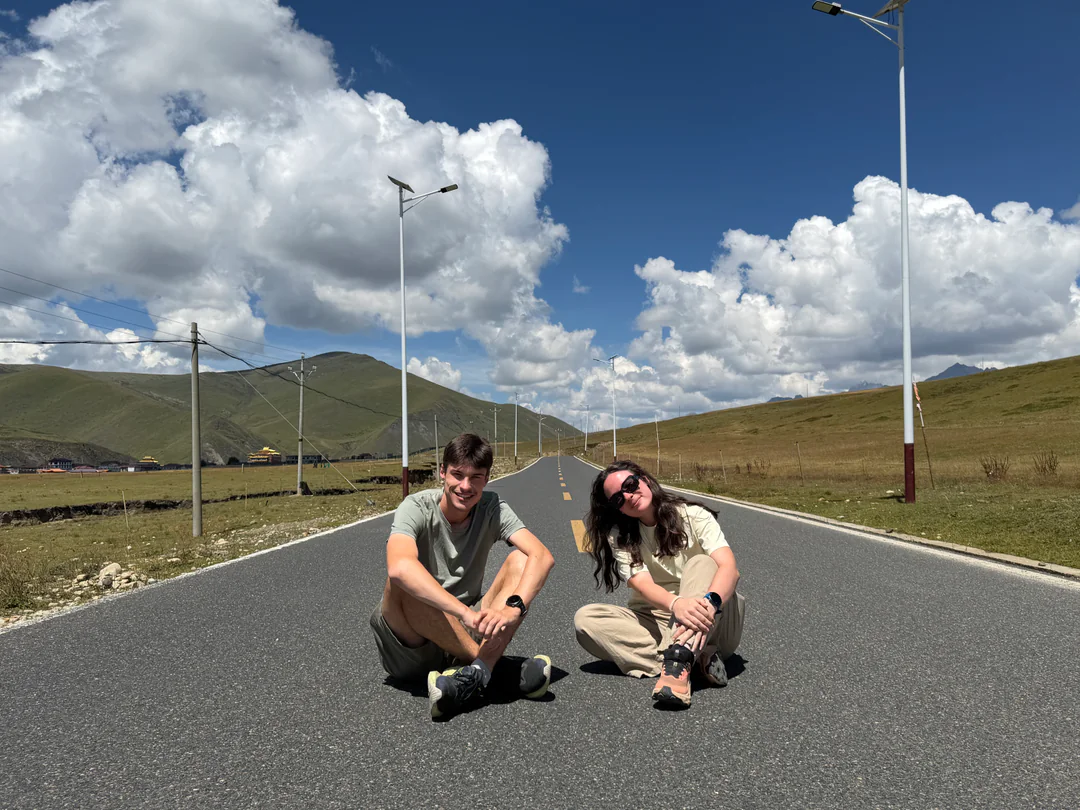 A group photo beneath a banner on a closed road