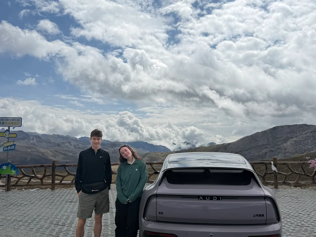Eva and Martin with the car used for the journey at a mountain pass