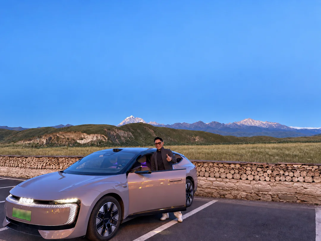 Ryan standing beside the open car door in the mountains of Western Sichuan